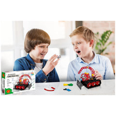 Two children excitedly assembling Alexander Constructor Snow Cat with colorful pieces on a white table.