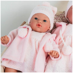 ASI Dolls Koke in pink duffle coat and knit hat, features lifelike blue eyes and delicate facial details.
