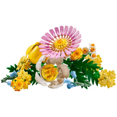 A colorful assortment of LEGO® flowers, featuring a large pink daisy, yellow petals, and vibrant spring blooms, arranged among green leaves.