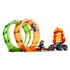 LEGO City Double Loop Stunt Arena featuring vibrant green and orange loops, a stunt biker jumping through, and a fiery backdrop with a monster truck ready for action.