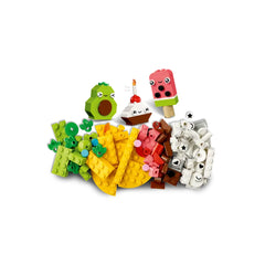 Colorful LEGO bricks arranged to create adorable food characters: an avocado, cupcake, ice cream, and taco, surrounded by various building pieces.