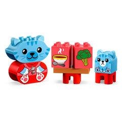 Blue and red LEGO® DUPLO® animal figures include a happy kitten and a sad bear cub next to a table with food blocks, illustrating daily routines.