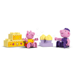 Peppa Pig and Grandpa Pig figures sit joyfully on colorful blocks, with a yellow sandcastle between them, embodying playfulness and creativity.