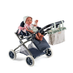 Cloe Baby Stroller with a doll, large cover, pink bow, and floral bag on handle.