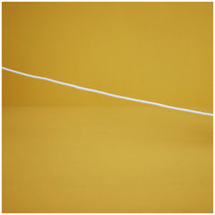 A white cotton cord stretches across a vibrant yellow background, suggesting playfulness and connection for children's toys.