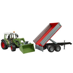 Green Fendt Vario 211 toy tractor with frontloader and red-tipped trailer on white background.