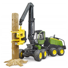Bruder John Deere 1270G Harvester toy in green with rotating cabin, gripping a brown tree trunk with a yellow claw.