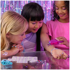 Cool Maker Shimmer Me Body Art Set is being used by three girls creating colorful temporary tattoos indoors.