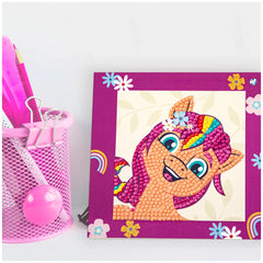 DIAMOND DOTZ Dotzies craft kit featuring a pink basket, pink ball, and purple pony frame in a retail packaging view.
