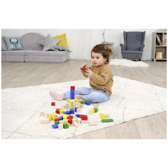 Young child on white shaggy rug playing with Eichhorn baby wooden colored blocks in various colors scattered around.