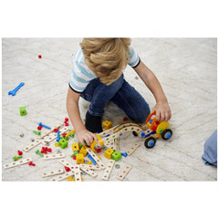 Eichhorn Constructor 3in1 construction set with colorful blocks and a toy car, engaging a young child on a carpeted floor.