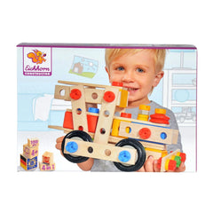Eichhorn Constructor wooden toy held by a smiling child, featuring colorful parts like wheels and a crane against a vibrant b