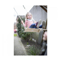 Eichhorn Outdoor Wooden Swing with a girl in pink top enjoying the swing in a garden on a cloudy day.