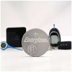Energizer Button Cell CR 2430 3V batteries with silver and black finishes, featuring logos on a white table.