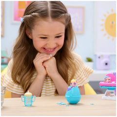 Hatchimals Alive Hungry Hatchimals Playset displayed on a table as a young girl smiles while engaging with the toys.