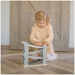 Label-Label-Car-Slider-Baby-Activity-Toys with a young girl on a light brown wooden floor next to a textured fabric furniture
