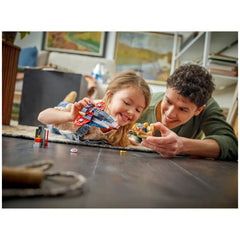 A young girl and an adult play on a wooden floor, smiling as they engage with LEGO action figures, including Captain America and a spaceship, surrounded by colorful building pieces.