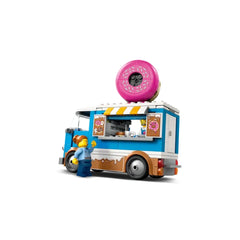 Colorful LEGO City Donut Truck with a giant pink donut on top, featuring a service window and minifigure serving a customer.
