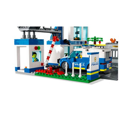 LEGO City Police Station set featuring a blue police car parked outside, a red and white barrier, and a character at the window.