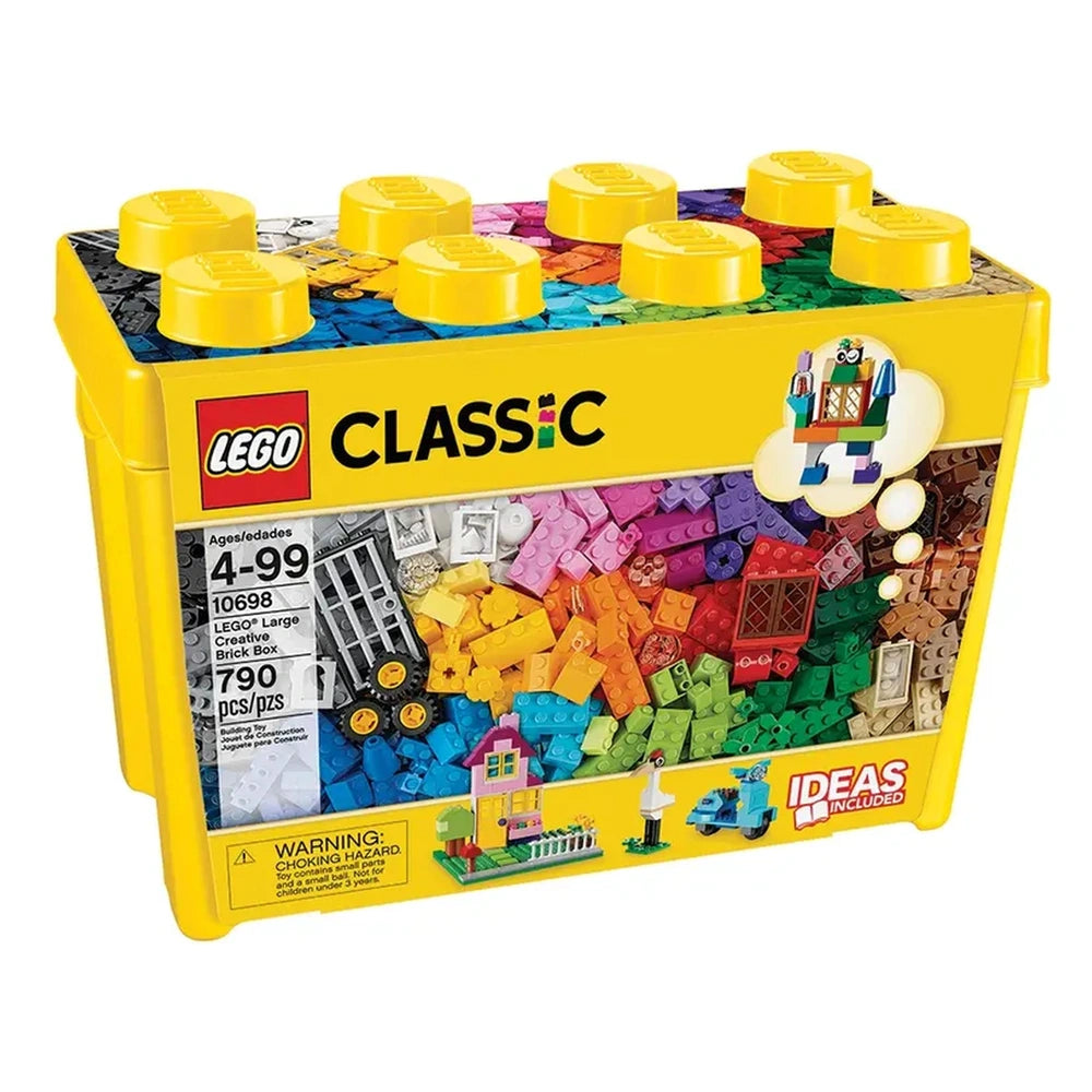 Bright yellow LEGO Classic box filled with colorful bricks, featuring a variety of shapes and sizes. The lid has rounded studs, and the front displays the logo and contents label, including a small house and vehicle build.