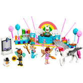 Colorful LEGO Friends costume party scene featuring a DJ booth, rainbow backdrop, and four minidolls in whimsical outfits. An enchanting unicorn and a cat figure enhance the festive atmosphere.