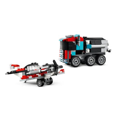 LEGO Creator Flatbed Truck in black and red beside a helicopter in grey and red, showcasing wheels and moving parts.