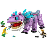 LEGO Fortnite Klombo construction set featuring a large purple creature with movable legs, an open mouth, and a red interior. Two minifigures, one dressed as a banana and another as a king, interact with the creature alongside a small bush and Klomberries on the ground.