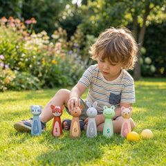 New Classic Toys bowling set features a child in a striped shirt playing with a smiling rabbit figurine on grass.