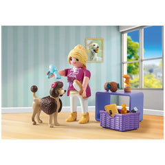 Playmobil Dog-Groomer toy playset featuring a plastic doll, toy dog, grooming tools, and accessories on a light wood floor.
