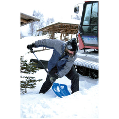 PROSPERPLAST Alpinus Alutube shovel in snow, with a person wearing white clothing standing beside a wooden structure and tree