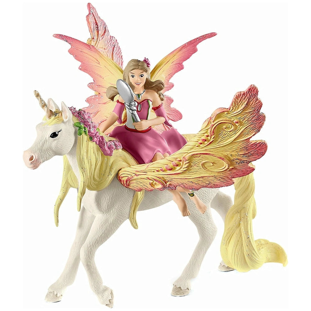 Feya, a fairy in a pink floral dress, rides a golden-maned unicorn against a plain white background.