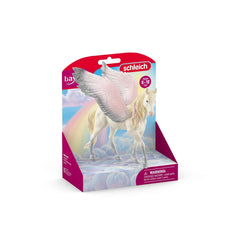 Schleich Sunrise Pegasus toy horse in glossy packaging with a colorful blue background, rainbow, and clouds, age 5-12.