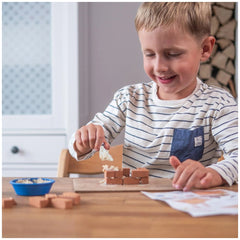 Teifoc castle building set is enjoyed by a smiling child in a striped shirt, surrounded by blocks and a blue bowl.