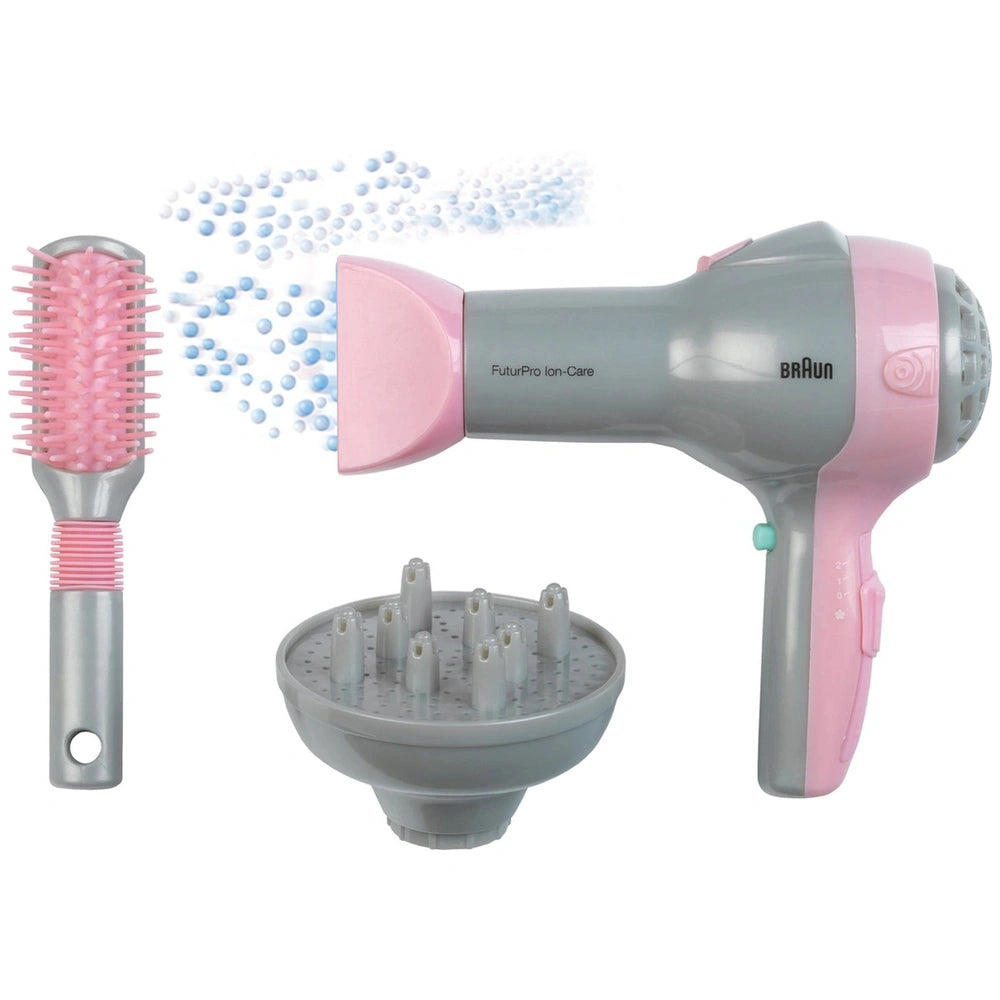 Theo Klein Braun hairdryer in pink and gray with diffuser, alongside a pink-bristled hairbrush with silver handle.