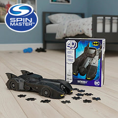 4D Build DC Batman Retro Batmobile 3D Puzzle Model Kit displayed in a room with a blue and white box next to a black toy car.