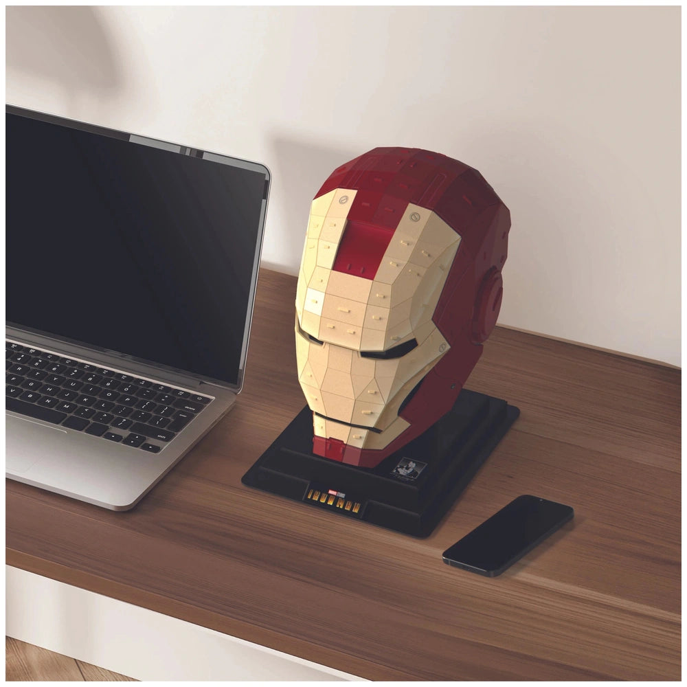 4D Build Marvel Iron Man 3D Puzzle Model Kit displayed on a wooden desk alongside a laptop and smartphone.