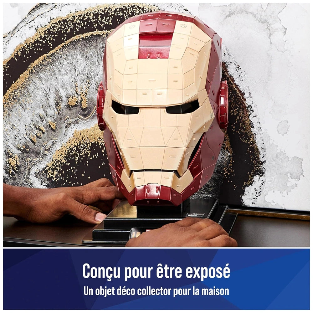 4D Build Marvel Iron Man puzzle model kit being assembled, featuring a metallic red and gold helmet on a textured surface.