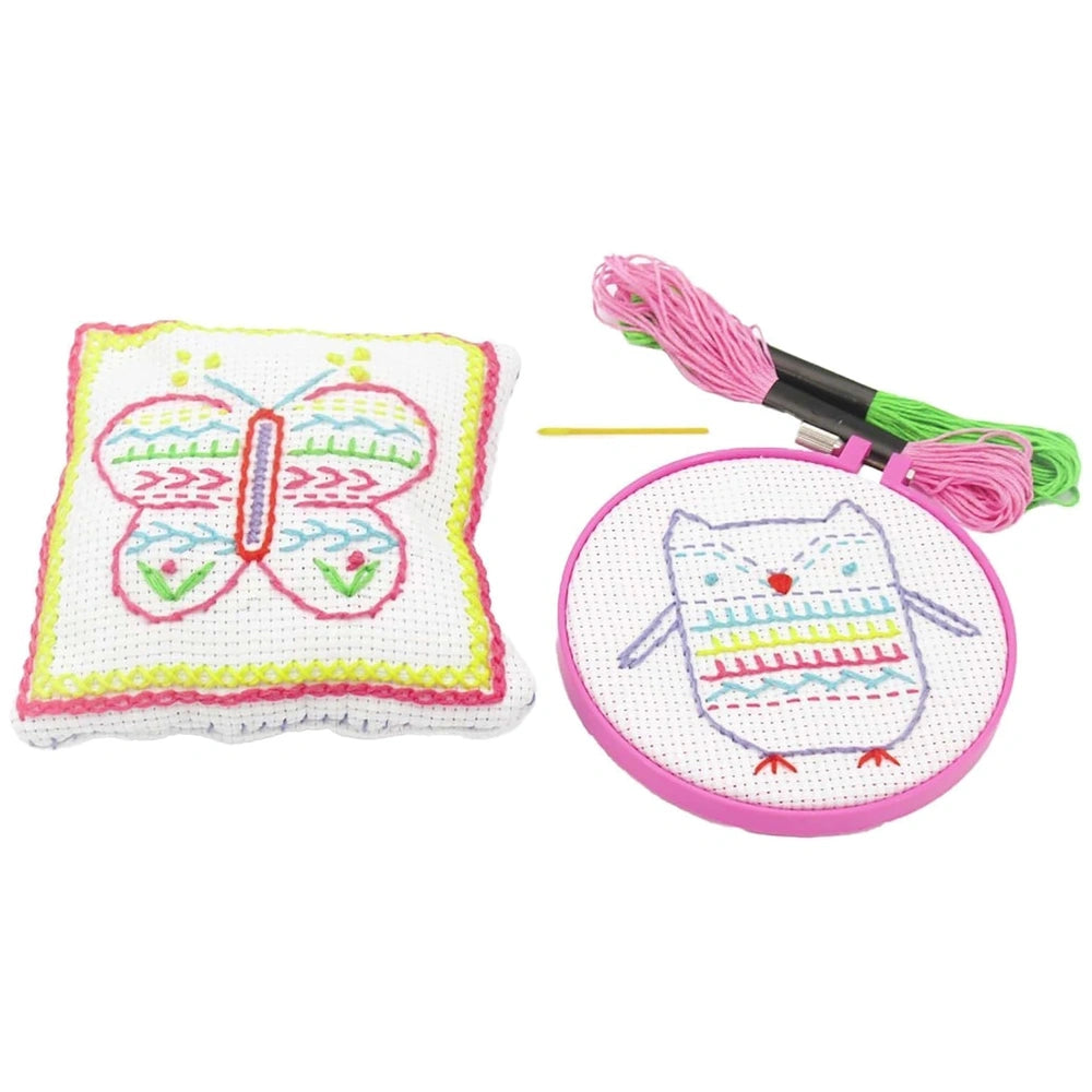 Yellow butterfly-shaped pillow with white embroidered fabric and hoop, featuring pink and green accents, for arts and crafts.