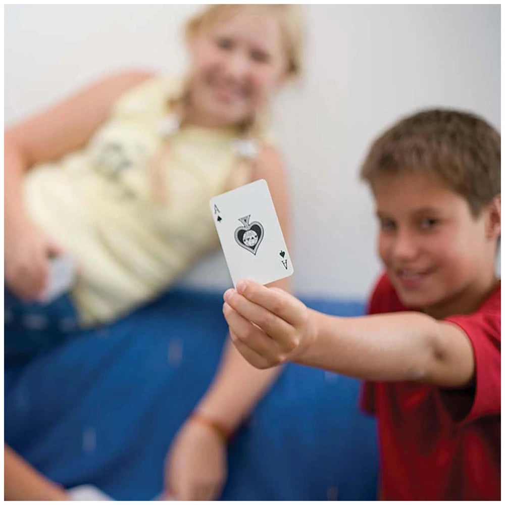 KidzLabs Magic Kit with a young girl in a yellow top and a boy in a red shirt, sitting on a blue couch, holding a glossy card