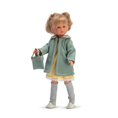 Celia doll in a green coat with stylish blonde hair, yellow dress, gray leggings, white shoes, and a matching handbag.
