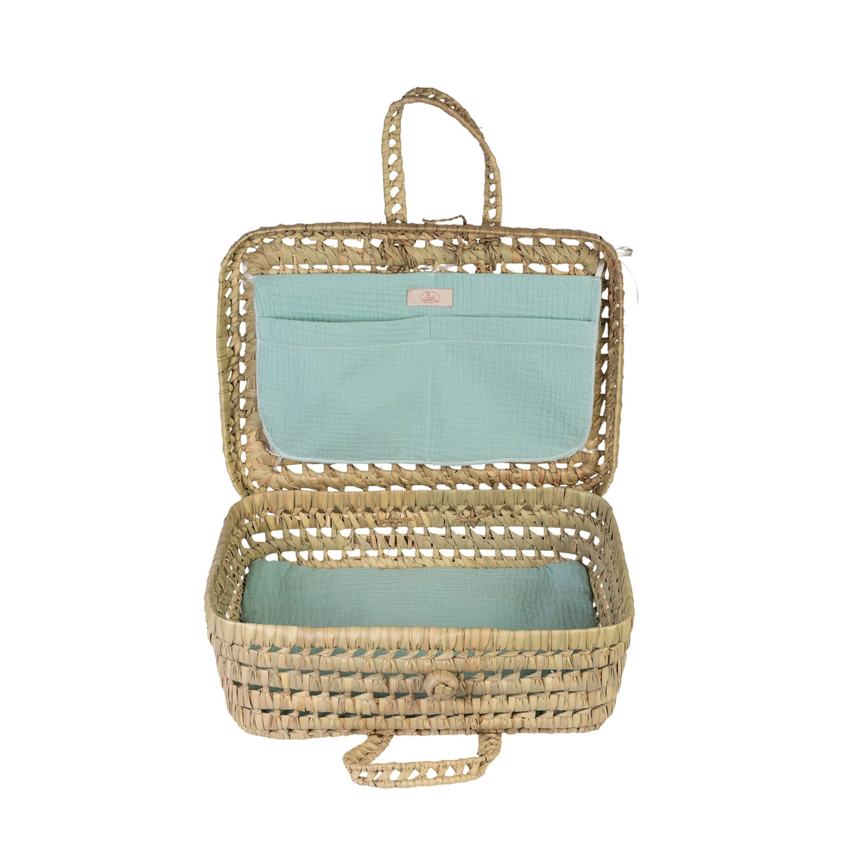 Open palm leaf suitcase with green muslin lining, featuring a woven handle and organizer pocket inside.