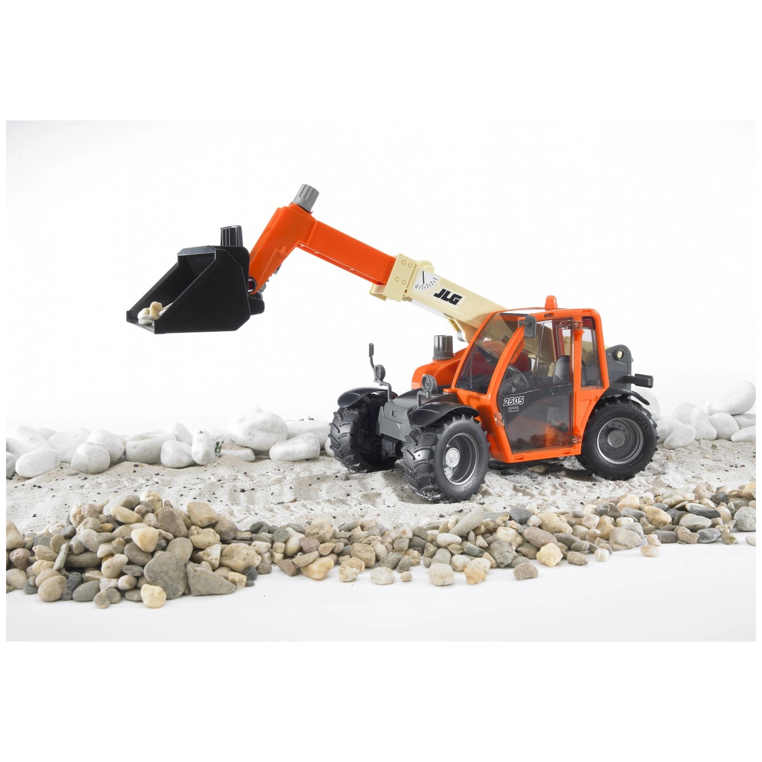 Orange Bruder JLG 2505 Telehandler toy with telescopic arm extended, lifting pebbles on a sandy and rocky surface.