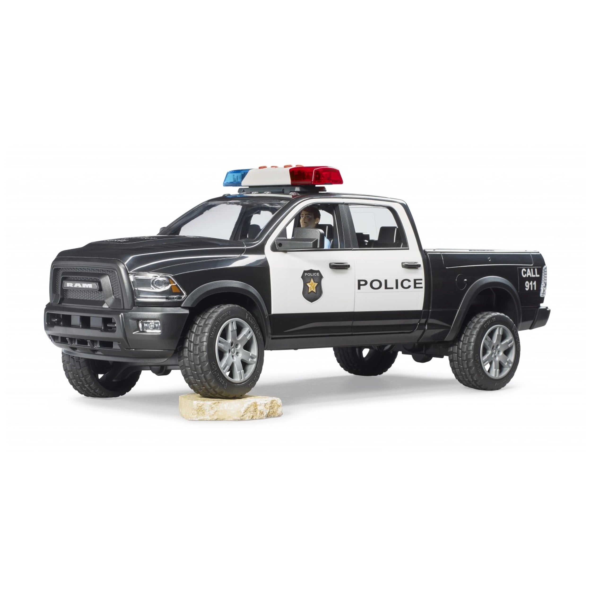 Bruder RAM 2500 Police Pick-Up Truck toy in black and white with a police officer, on a white background.