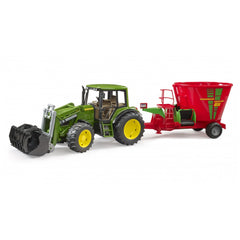 Green toy tractor with yellow wheels connected to a red Bruder Strautmann Verti-Mix 1050 fodder mixer on white background.