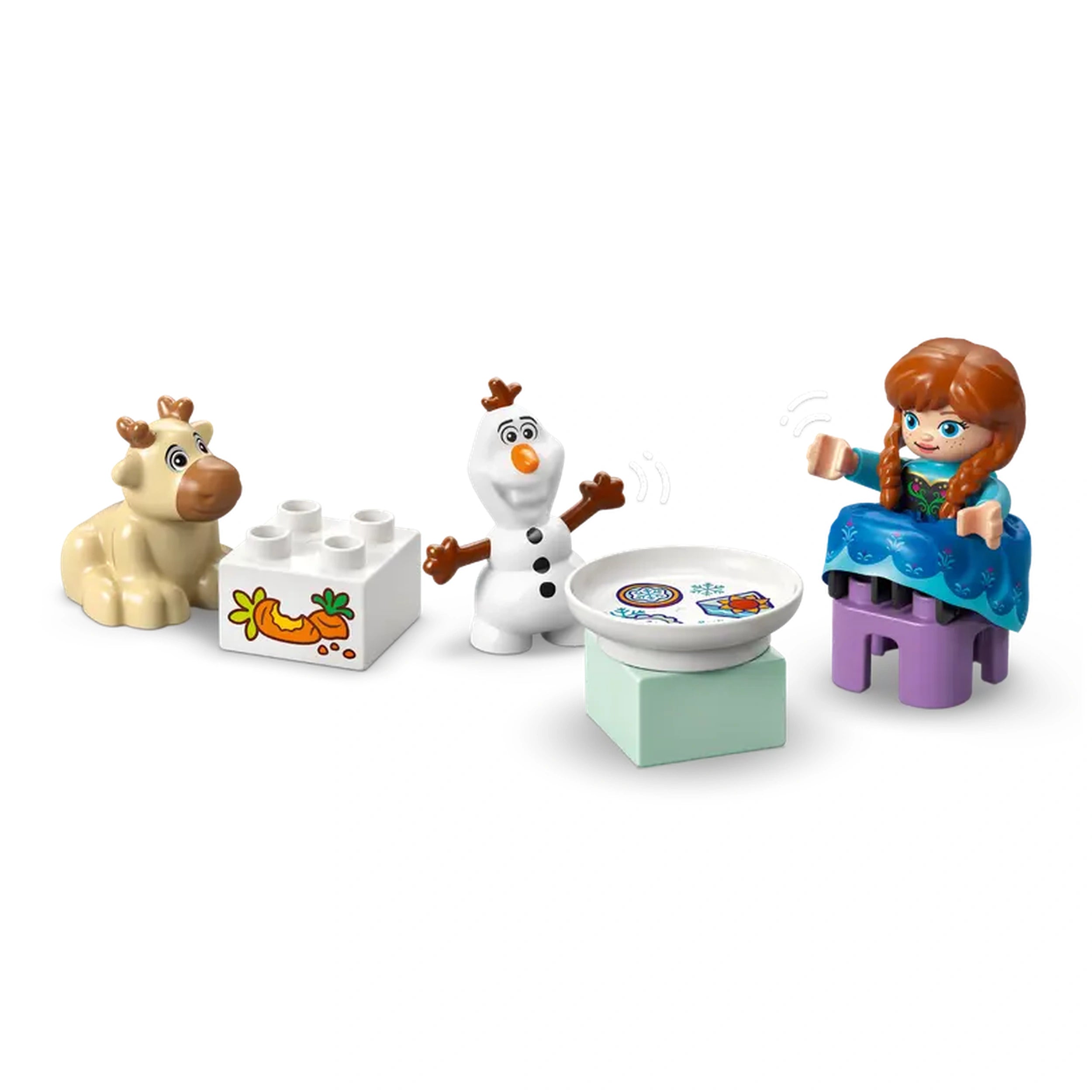 Anna sits on a purple block wearing her signature blue dress, smiling beside Olaf, who gestures joyfully. Baby Sven, a beige reindeer, rests nearby next to a white LEGO brick decorated with a carrot design. A round plate is placed on a light green block, adding to the playful scene inspired by Disney's Frozen.