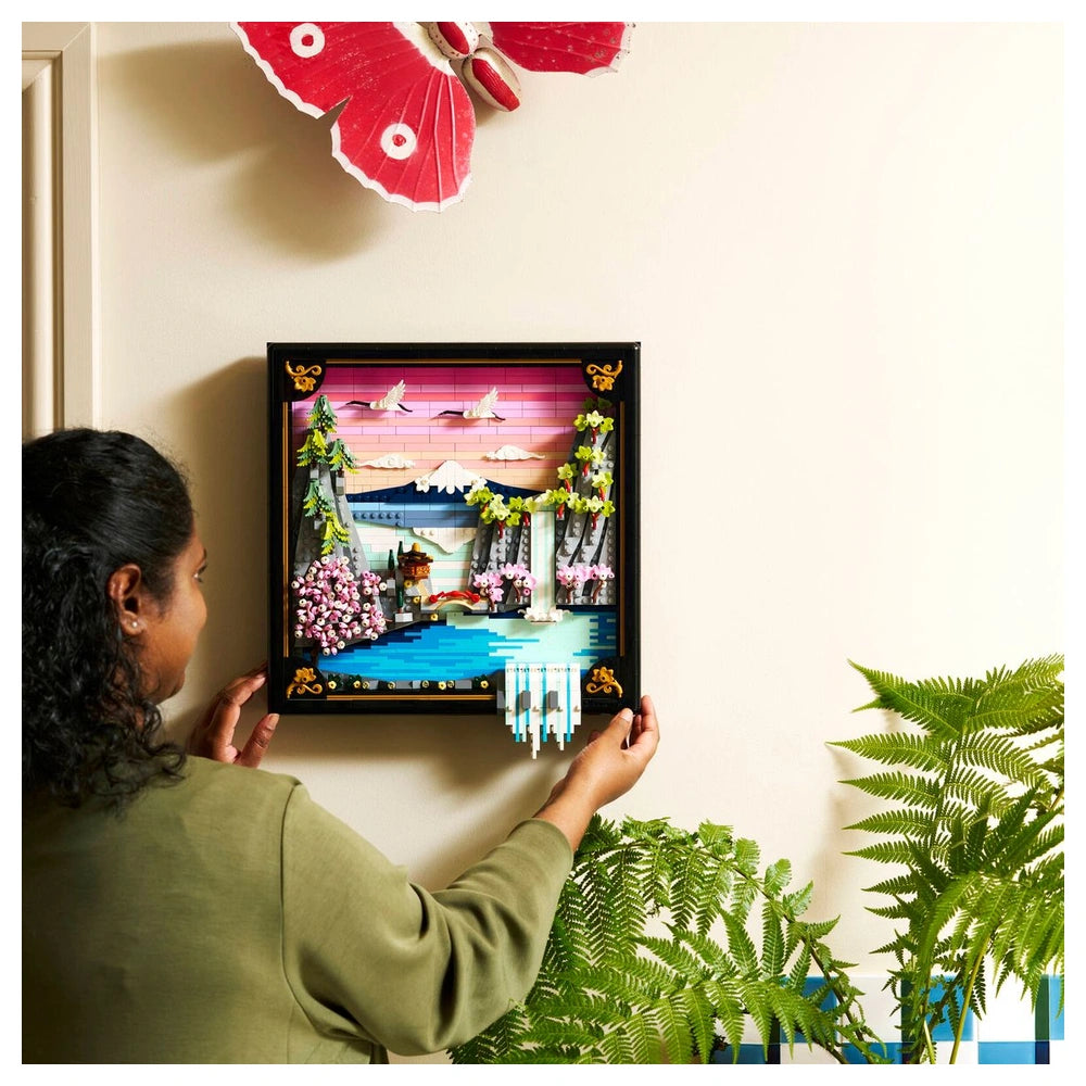 LEGO Art set featuring a colorful Japanese cherry blossom landscape, held in a black wooden frame against a white wall.