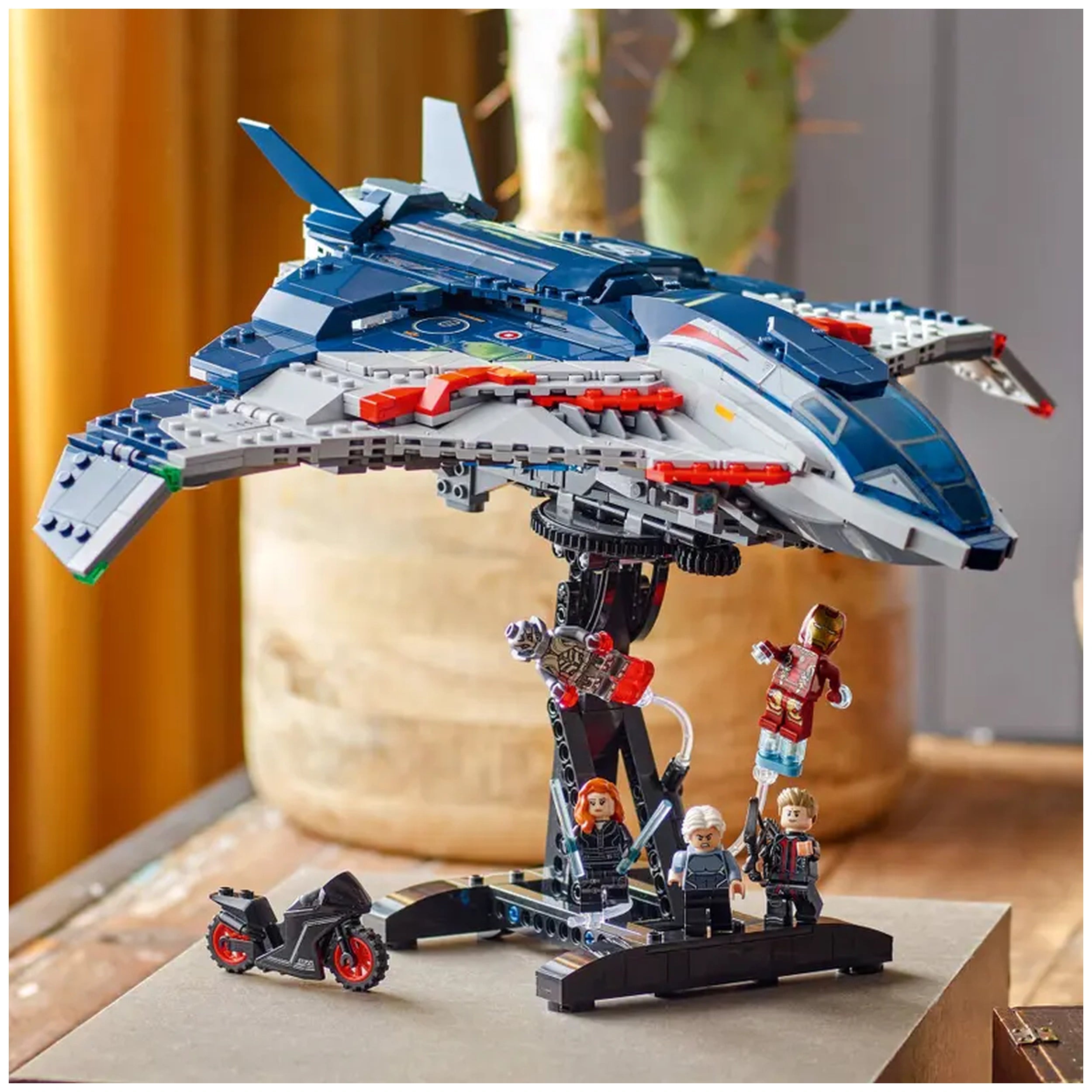 LEGO Quinjet from Avengers: Age of Ultron set, featuring intricate details, minifigures, and a small motorcycle, displayed on a stand.
