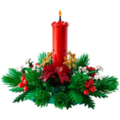 Bright red LEGO candle with a flame stands in a festive arrangement of lush green foliage, golden stars, and cheerful red berries.