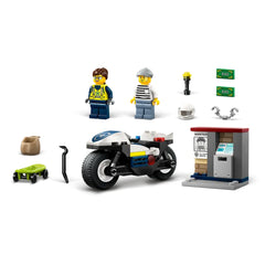 Two LEGO minifigures, a police officer and a crook, stand beside a blue police motorcycle. A green skateboard, a bag, and various accessories including a helmet and money bills are visible. An ATM with a "WANTED" poster is included, enhancing the playful chase scene.