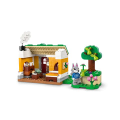 Colorful LEGO Creative Houses set featuring a cozy house with a decorative chimney, a wooden interior, and a charming animal figure beside a green tree and flowers.